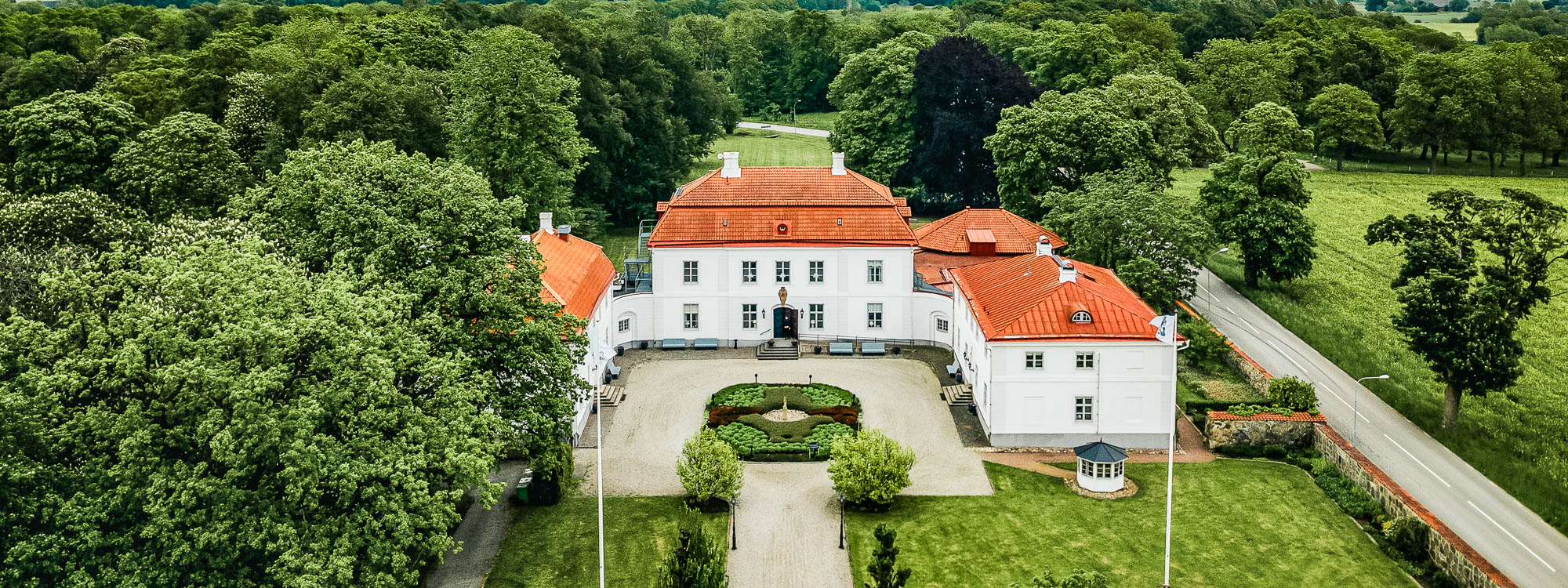Flygbild på Bjärsjölagårds Slott inbäddat i den grönskande naturen.